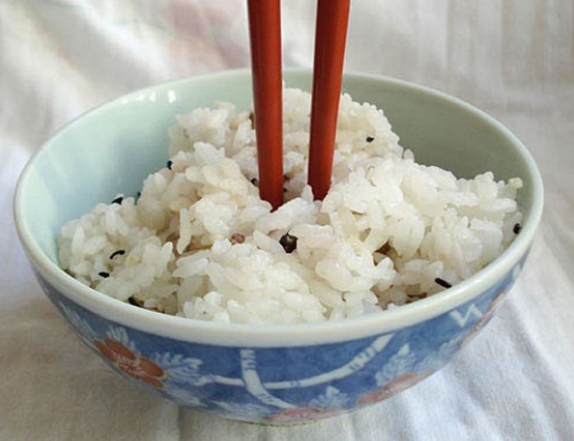 clavar los palillos en el bol de arroz