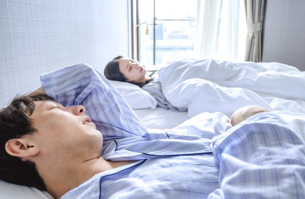 pareja japonesa durmiendo en camas diferentes